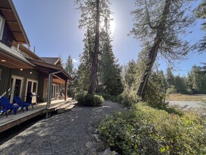 Un chalet doté d’une terrasse couverte, de meubles de jardin et d’un chemin en gravier.
