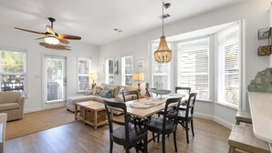 A spacious living room with a dining area, large windows with blinds, a ceiling fan, and a chandelier. - Wine Down- 300 yards to the Beach- Overlooking Community Pool- 2 Bikes (Santa Rosa Beach)