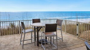 A patio with a table and chairs overlooking the ocean. - Wine Down- 300 yards to the Beach- Overlooking Community Pool- 2 Bikes (Santa Rosa Beach)