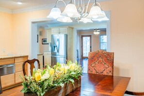 Un comedor con una mesa de madera, un centro de mesa floral y una silla estampada.