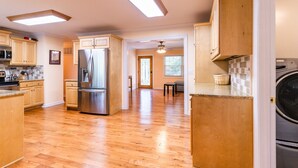 Una cocina amplia con armarios de madera, un refrigerador de acero inoxidable y un horno empotrado.