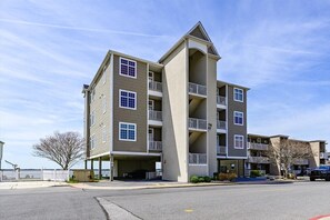 Un edificio residenziale a più piani con cortile centrale, balconi e area parcheggio.