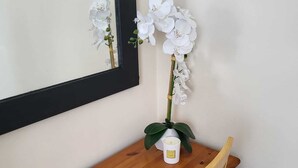 A wooden desk with a white orchid and a small white candle. - 1 Bed Retreat-sleeps 2-secure Parking-garden (Ennis)