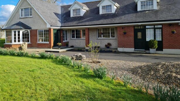 A two-story house with a brick facade, a front porch, and a small garden area. - 1 Bed Retreat-sleeps 2-secure Parking-garden (Ennis)