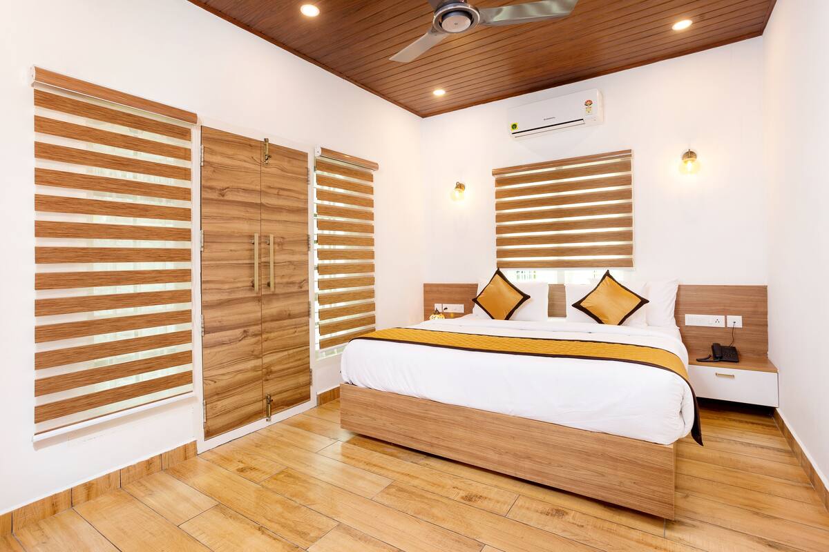 Quarto moderno com cama de madeira, armários embutidos e ventilador de teto.