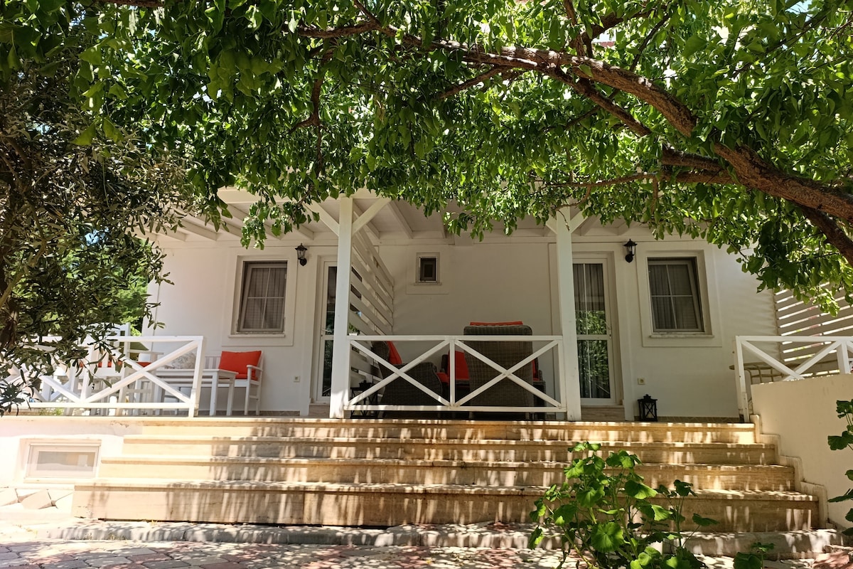 A two-story building with a porch, steps, and a railing.