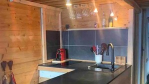 A modern kitchen with wooden walls, a black countertop, and a built-in sink. - Magnificent apartment with stunning views❤️Schuss⛷ (Tignes)