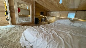 A cozy bedroom with a large bed, fluffy white rug, wooden walls, and a mirror. - Magnificent apartment with stunning views❤️Schuss⛷ (Tignes)