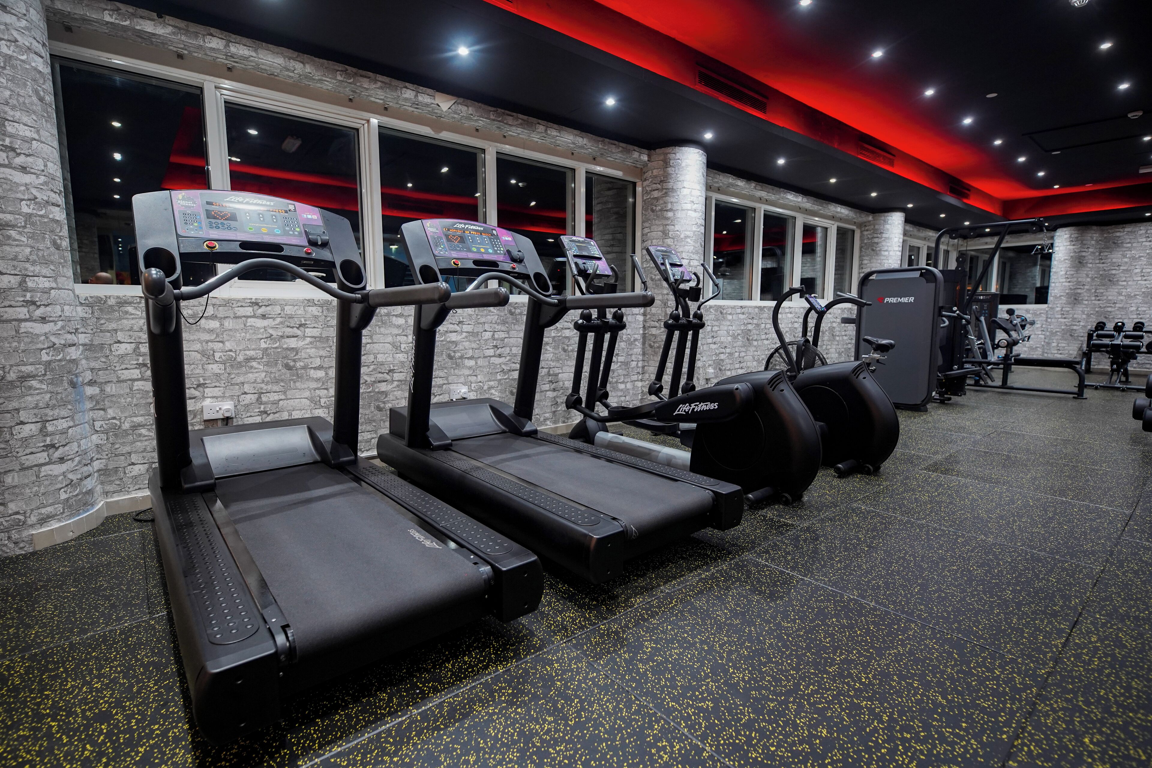 A gym with treadmills, elliptical machines, and weight machines.