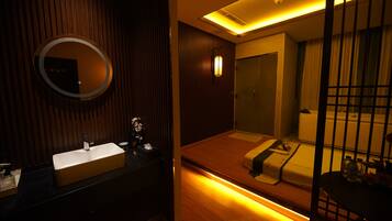 A modern bathroom with a large mirror, a sink, and a wooden vanity.