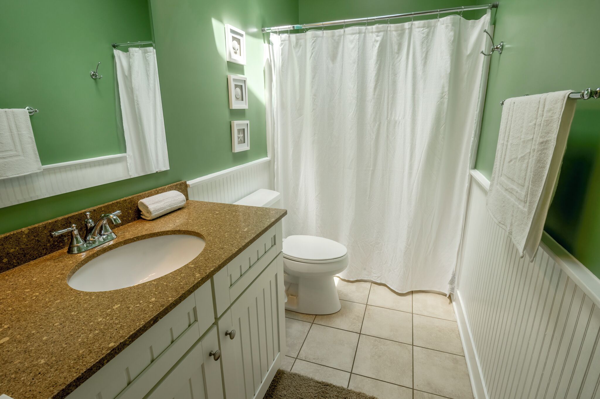 Une salle de bain équipée d’un lavabo, de toilettes et d’un rideau de douche.
