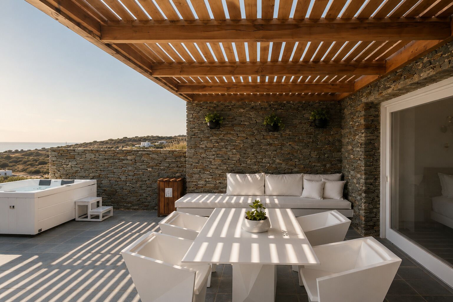 Terraza en la azotea con muro de piedra, pérgola de madera, mobiliario exterior blanco y un jacuzzi.