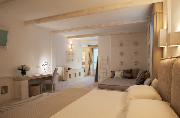 Una habitación de hotel moderna con una cama grande, un escritorio y una zona de estar.