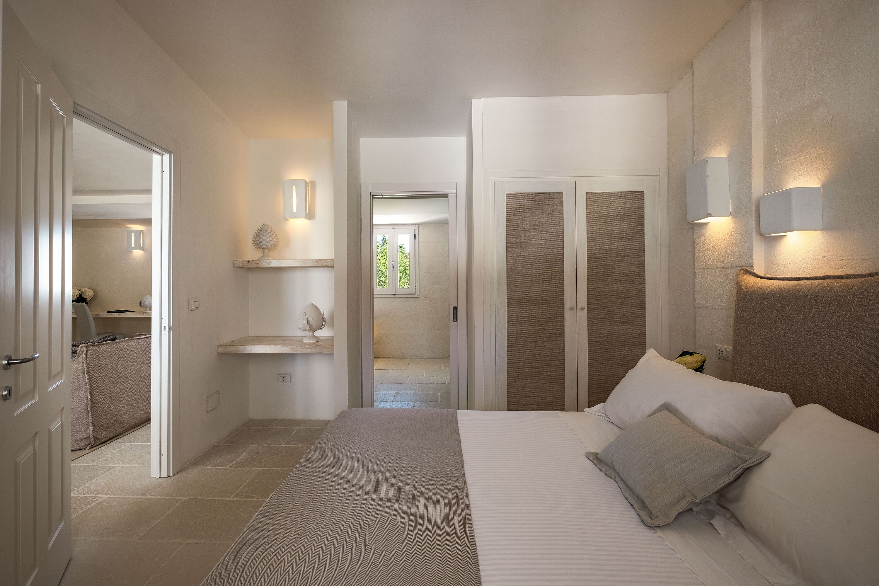 Ein Schlafzimmer mit einem großen Bett, einem Nachttisch, einem Spiegel und einem Kleiderschrank.