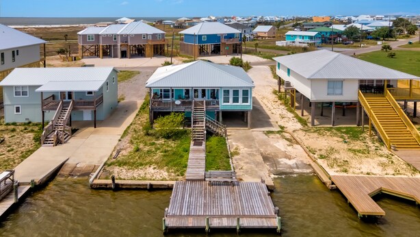 Una zona residencial costera con casas sobre pilotes, conectadas por pasarelas.