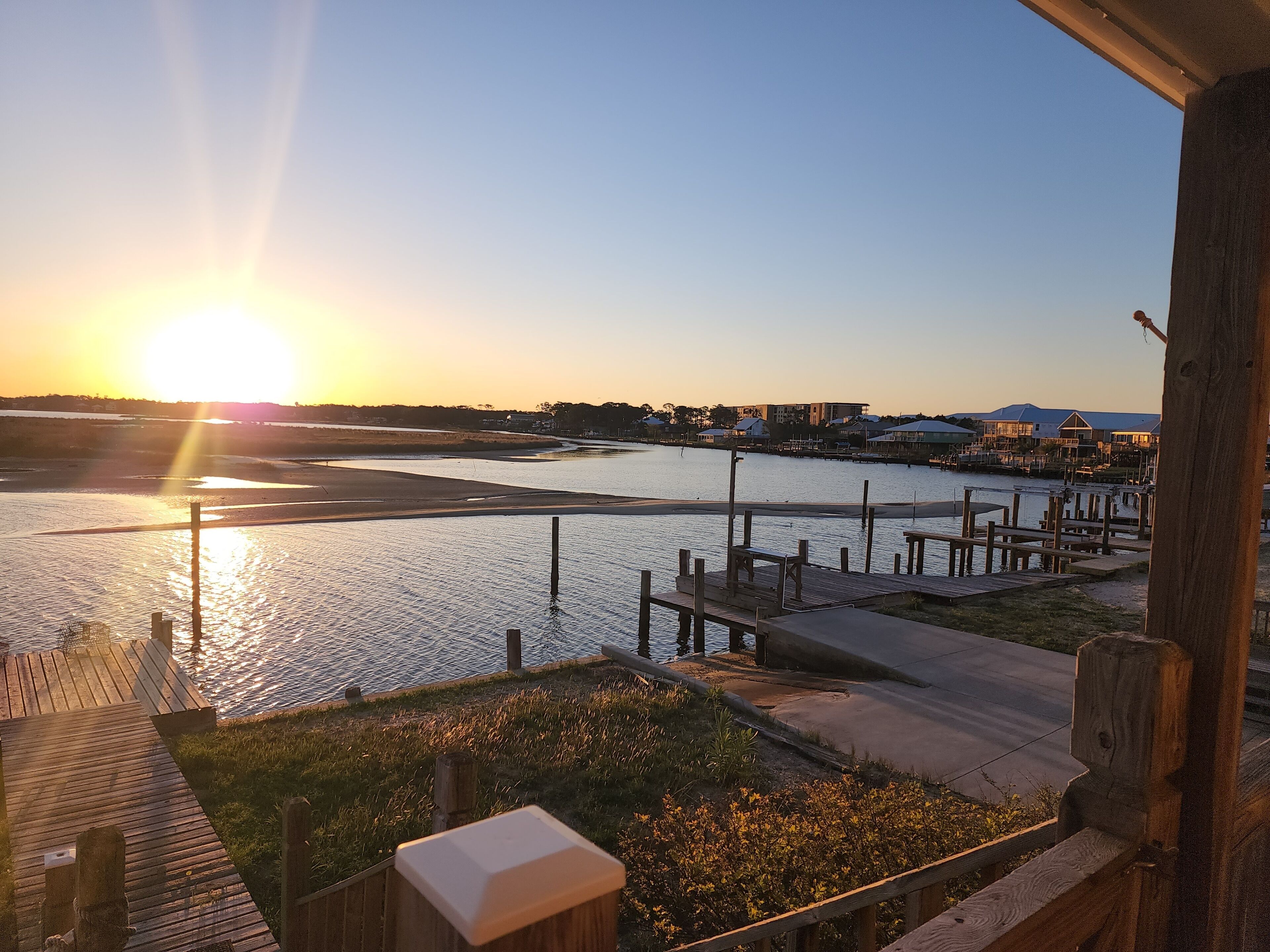 A riverside view with wooden docks and a sunset.