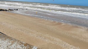 Una platja amb cel blau i onades.