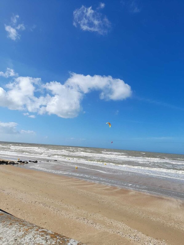 Una playa con cielos despejados y olas.