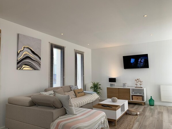 A modern living room with a sofa, a coffee table, a TV, and a cabinet.