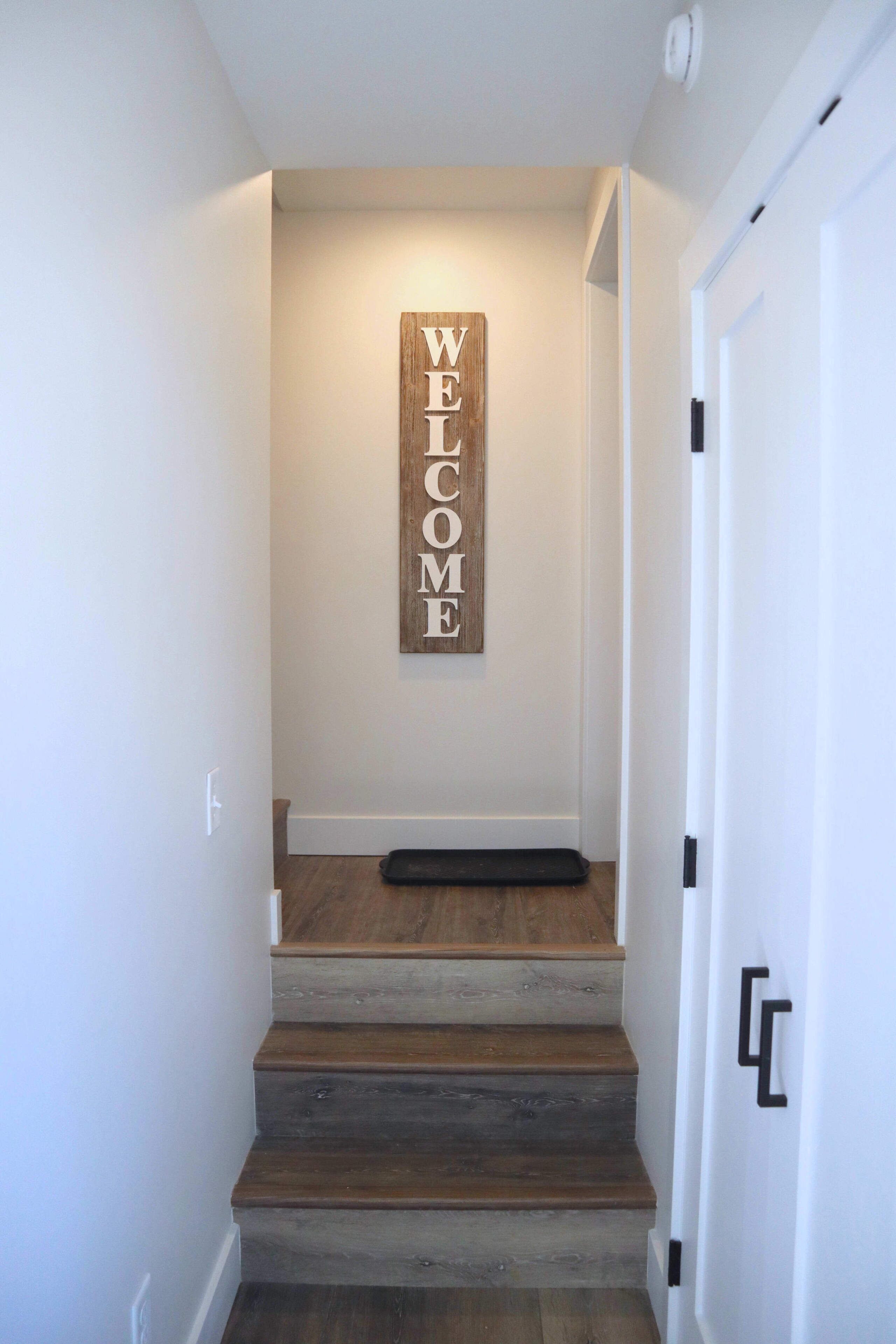Una escalera con un cartel de bienvenida de madera.
