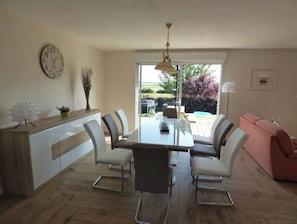 A modern kitchen with a dining table, chairs, and a clock on the wall. - Le Gîte du Marais d' Opale **** Bazinghen (Bazinghen)