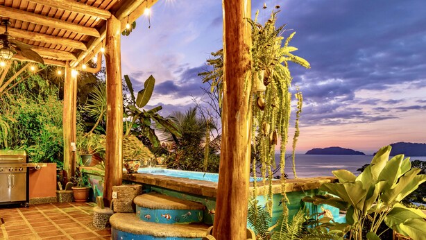 A covered outdoor area with a pool, wooden pergola, and potted plants. - Ocean View 🌅Infinity Pool Villa & Hot Tub !CLOSE TO BEACH! (Jaco Beach)