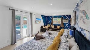 A modern living room with a pool view, a sofa set, and a large wall mural.