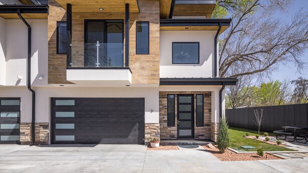 A modern two-story house with a garage, large windows, and a well-maintained lawn. - Downtown Retreat | Steps to Bike Path &Restaurants (Moab)