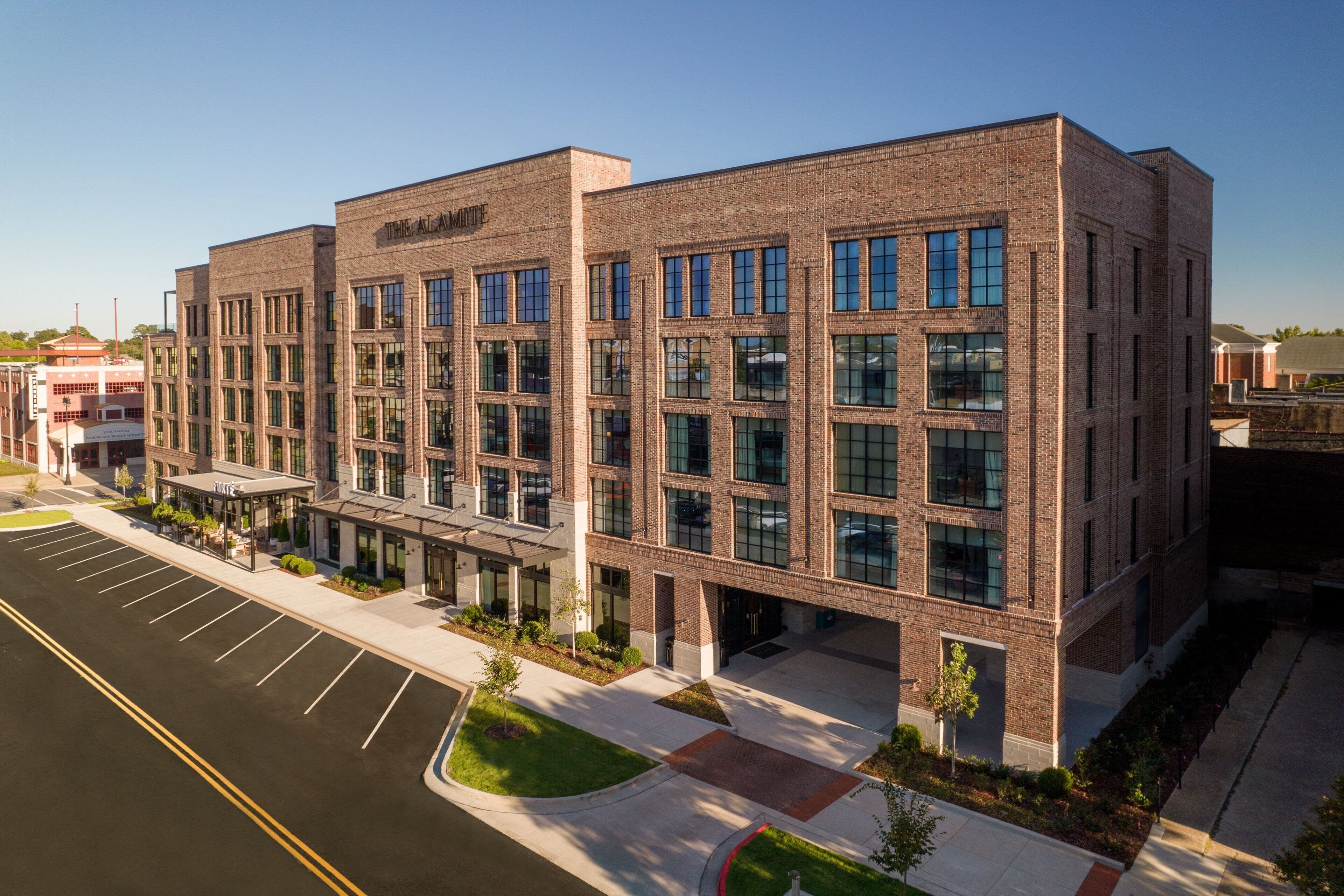 A modern brick building with multiple windows and a covered entrance.