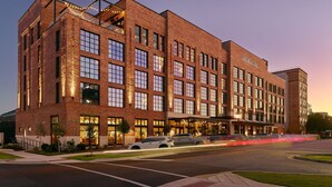 A large brick building with multiple windows and a sign that reads "The Alamo Hotel."