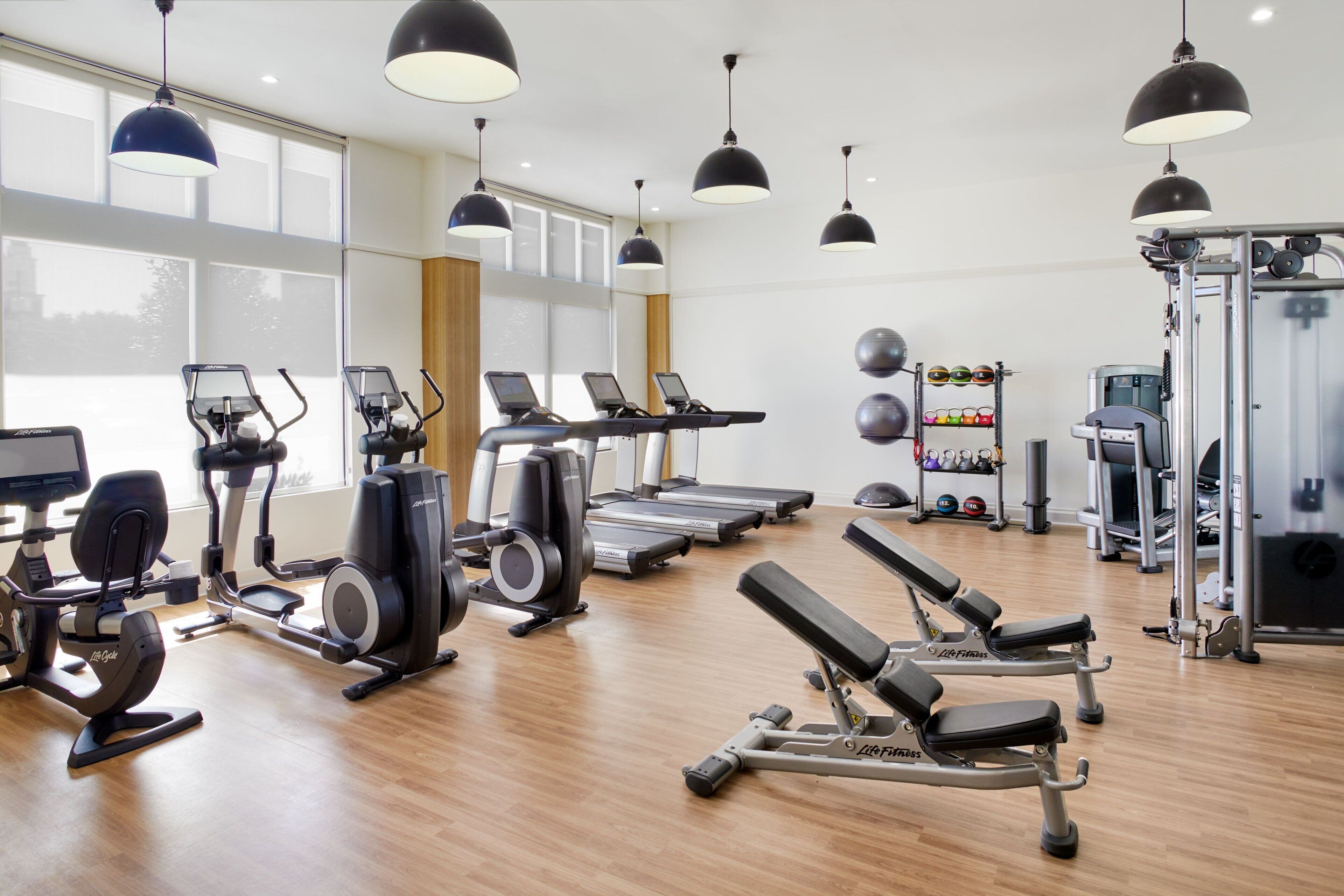 A gym with treadmills, elliptical machines, and weightlifting equipment.