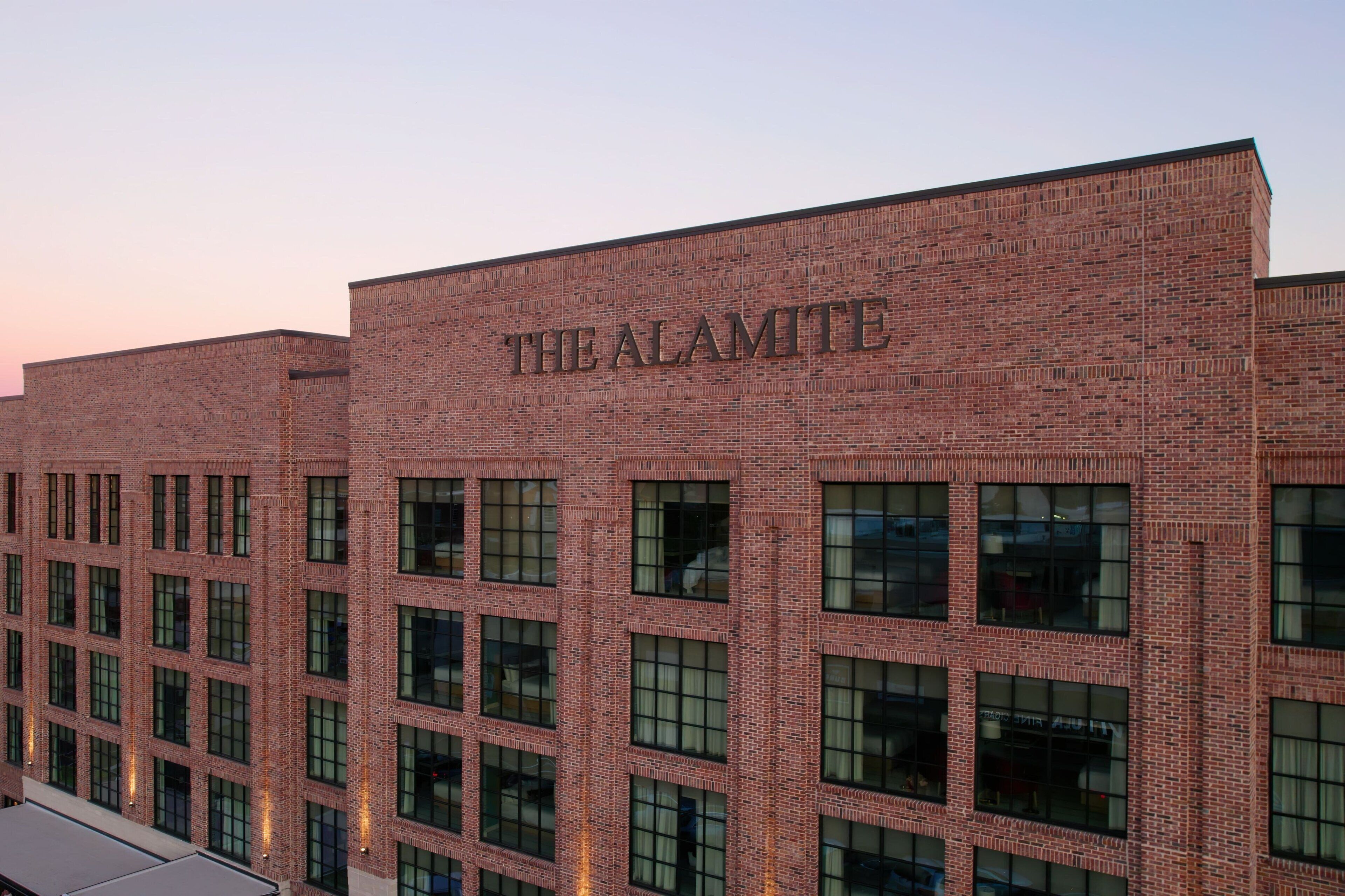 Un edificio de ladrillo con el nombre 'THE ALAMITE' visible en la fachada.