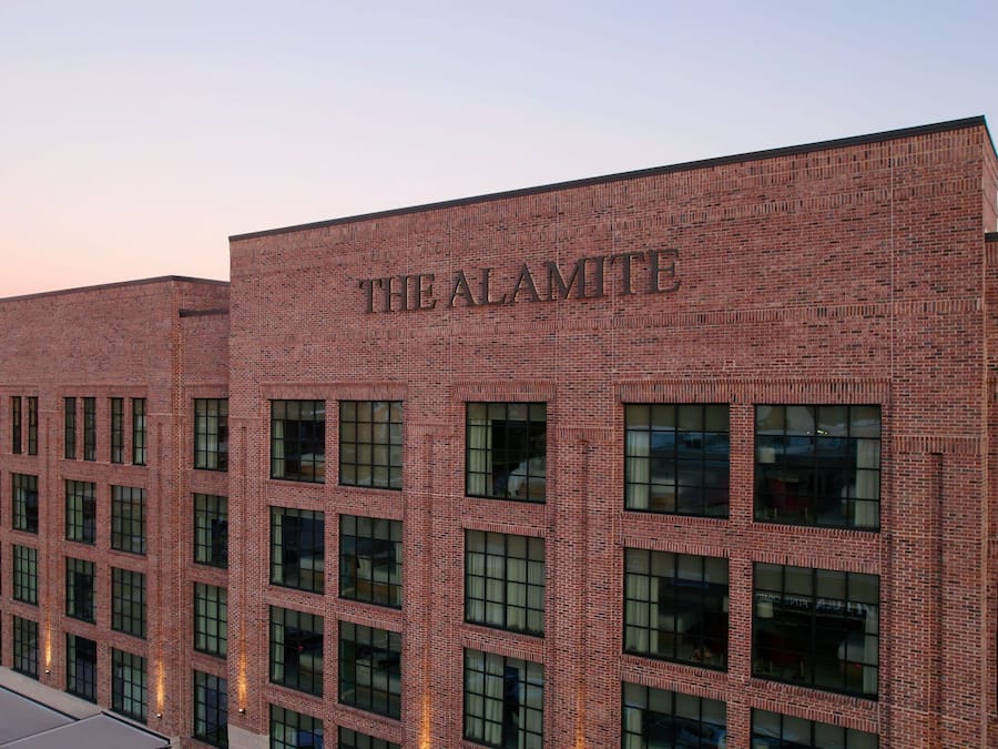 Un edificio de ladrillo con el nombre 'THE ALAMITE' visible en la fachada.