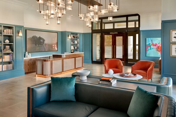 A modern living room with a sofa, chairs, a coffee table, and a bookshelf.