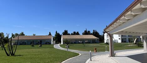 Une cour intérieure avec deux bâtiments, un chemin piétonnier et un petit jardin.