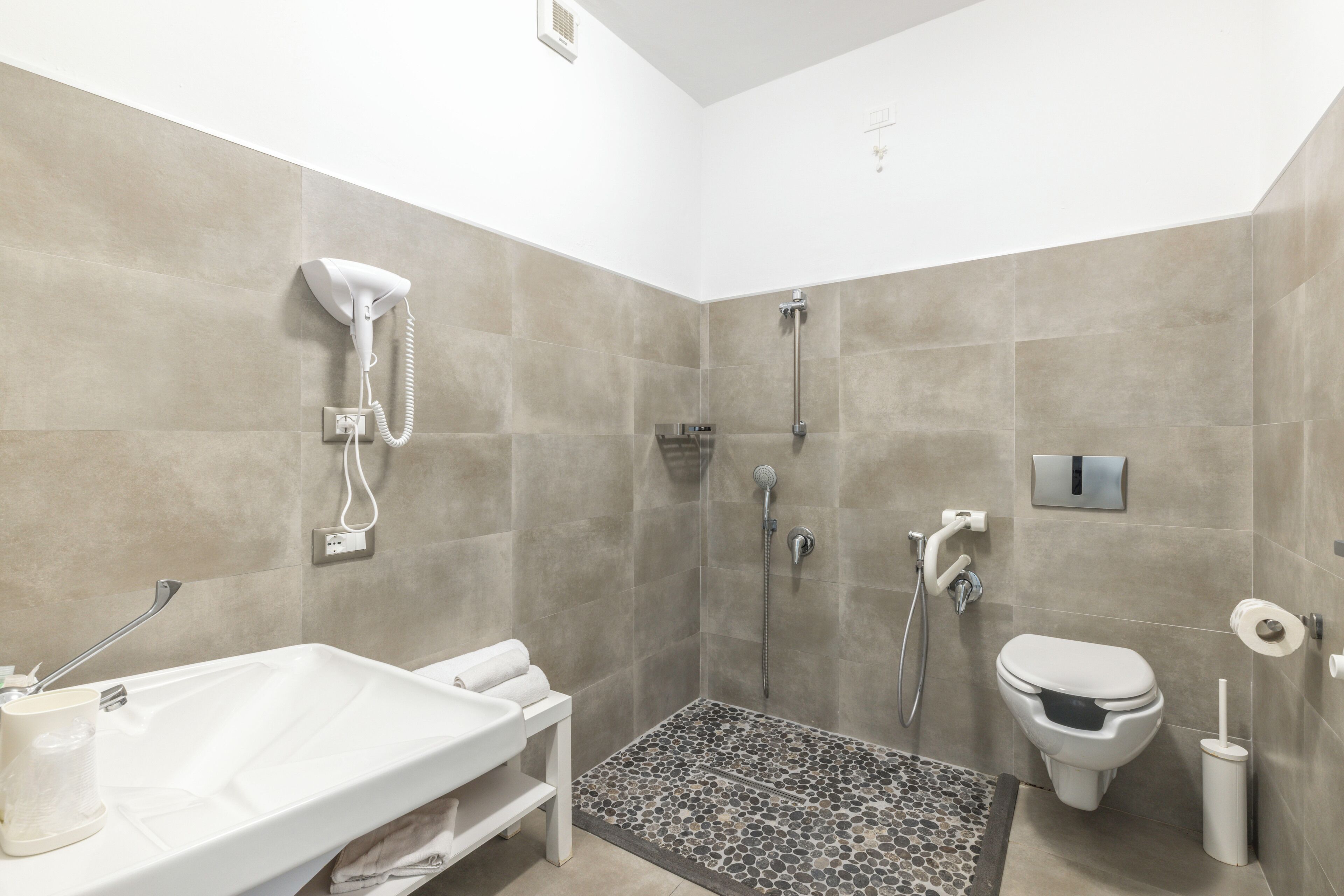 Une salle de bain avec douche, toilettes et lavabo.
