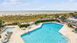 Un complexe hôtelier doté d’une piscine, offrant une vue sur la plage et comprenant un espace détente.