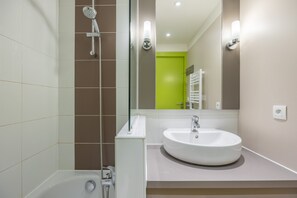 A modern bathroom with a bathtub, a sink, and a shower.