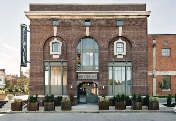 A brick building with arched windows and a sign reading "BELLWETHER."