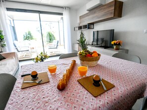 Enjoy a delicious breakfast in this stylish dining area with a table set for a meal, featuring a variety of breakfast items and a beautiful view.