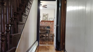 A wooden staircase leading to a room with a brick fireplace and a ceiling fan. - The Ole Farmhouse at Warm Springs  - Country Living For the Whole Family (Landisburg)