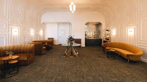 A spacious lobby with a patterned carpet, a central round table, and two sofas. - Glenmary Suite 204 at The Bellwether Hotel (Louisville)