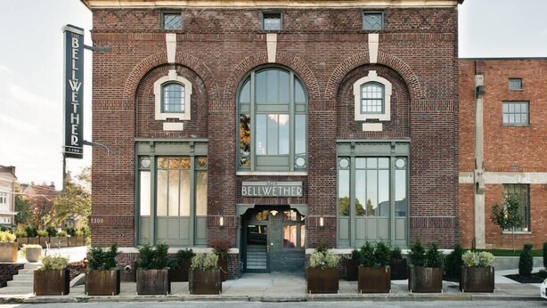 A brick building with arched windows and a sign reading "The Bellwether." - Glenmary Suite 204 at The Bellwether Hotel (Louisville)
