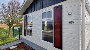 Ein Haus mit der Nummer 4105, einer Garagentür und einem kleinen Garten mit Baum und Mulch.