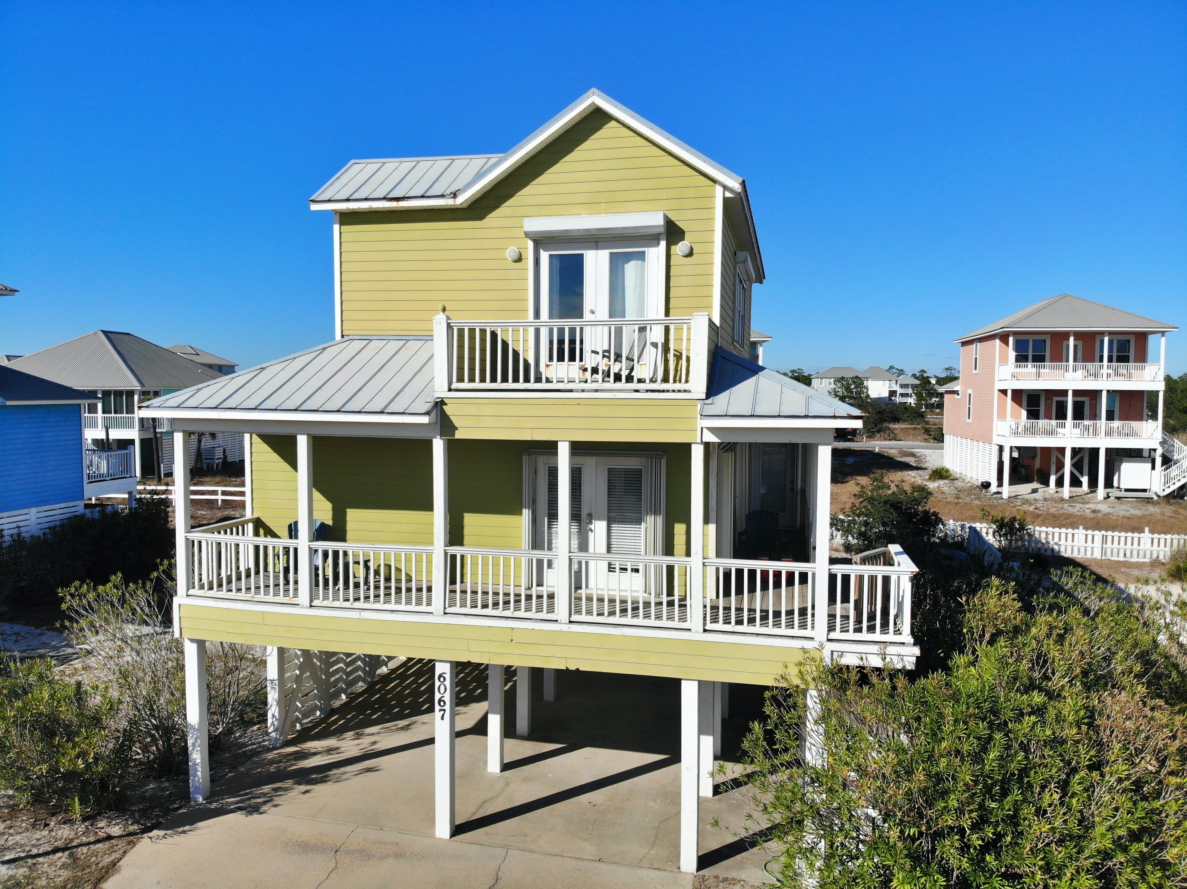 A two-story house with a balcony on the ground floor and a second-floor balcony.