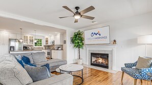 A modern living room with a grey sofa, a round coffee table, and a fireplace. - Castlewood Retreat | Views, Hot Tub & Foosball Table🛁🏔️ + Biltmore Pass (Alexander)