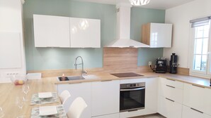 A modern kitchen with white cabinets, a wooden countertop, a built-in oven, and a coffee machine. - 3 bedroom house in La Môle, Gulf of Saint Tropez in residence with swimming pool (La Mole)