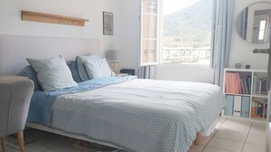 A bedroom with a bed, a nightstand, a bookshelf, and a window with a view of the outdoors. - 3 bedroom house in La Môle, Gulf of Saint Tropez in residence with swimming pool (La Mole)