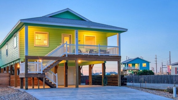 A two-story house with a balcony and a covered porch. - Crustacean Station- Private Pool - Cart Discount (Port Aransas)