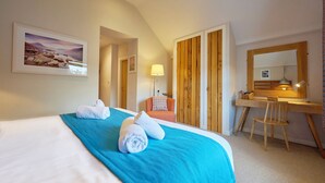 A hotel room with a bed, a desk, a chair, a lamp, and a mirror. - Howe Keld 5 First Floor (Keswick)
